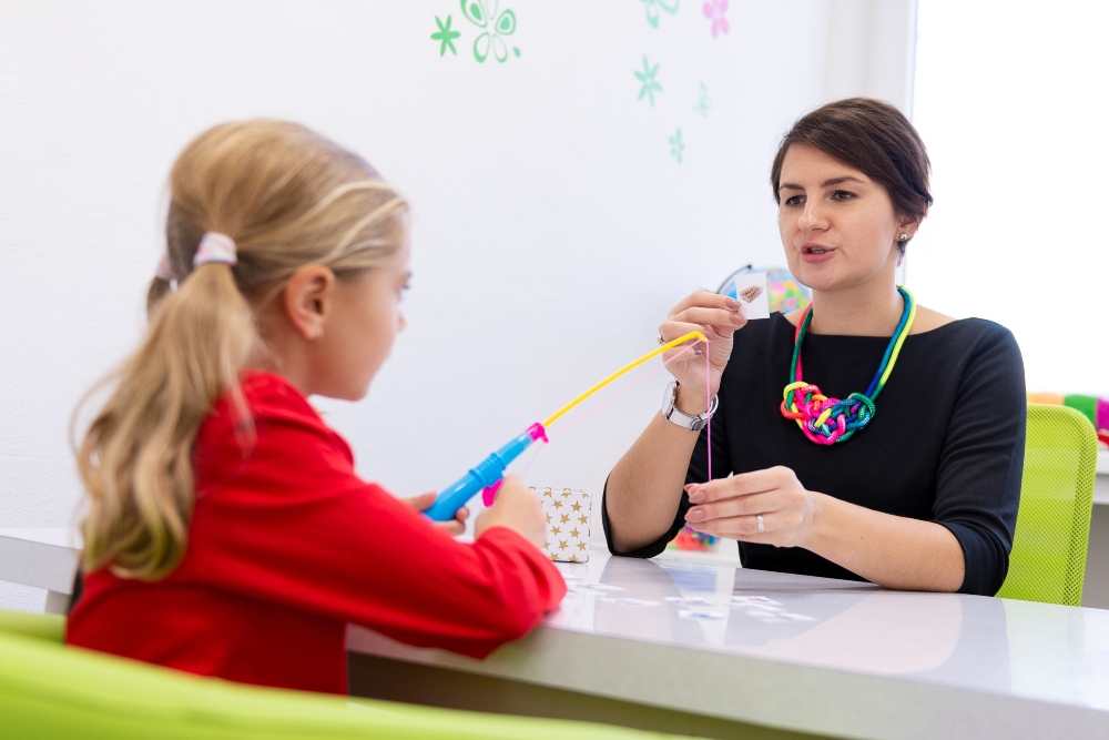 Occupational therapist completing a playful exercise with young girl